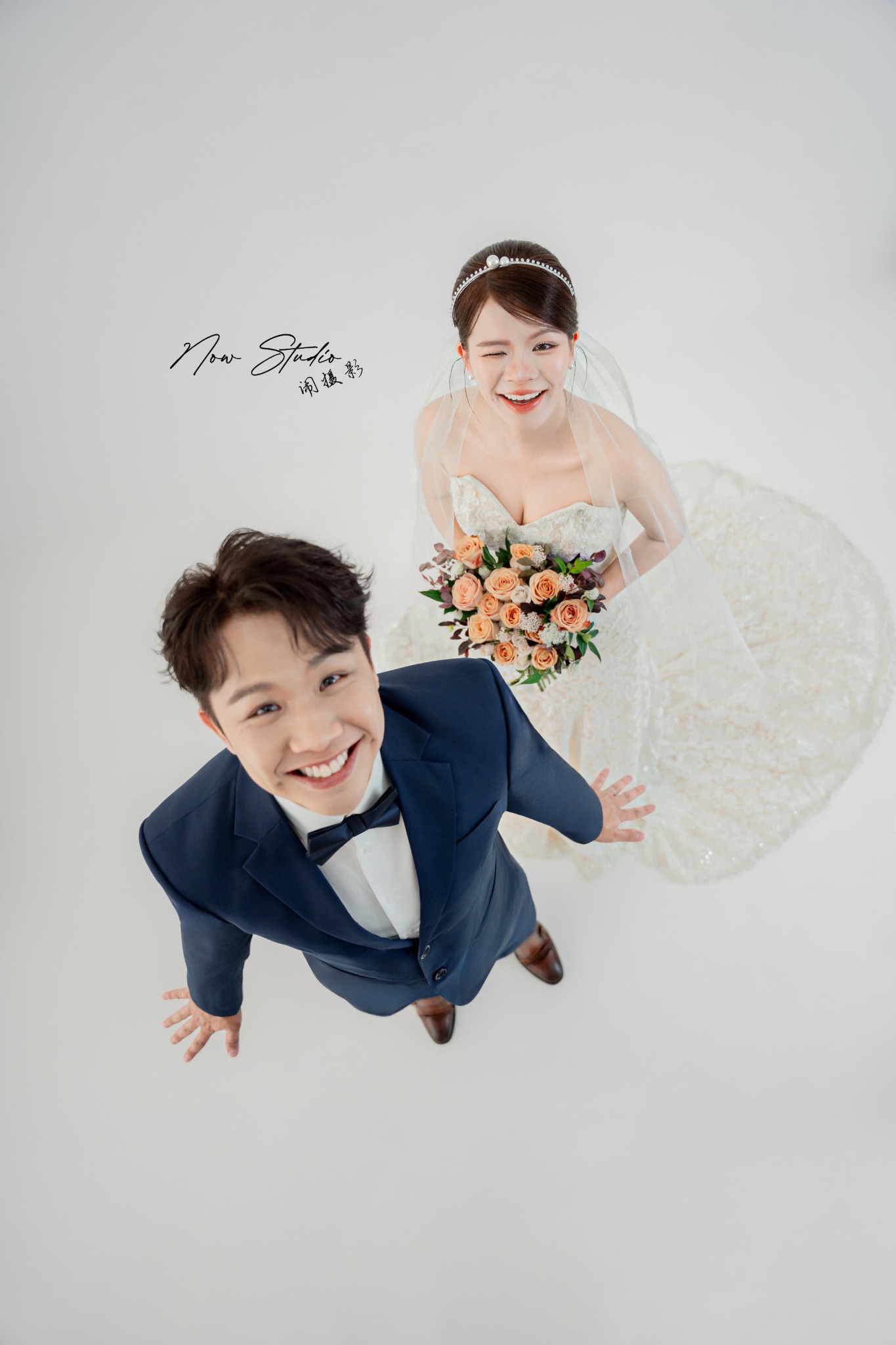 笑容灿烂的新人抬头看向镜头，完整直幅婚纱客照